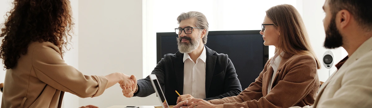 Candidate shaking hands with an interview panel in a meeting room